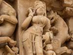 A woman applying makeup carving at Parsvanath Temple