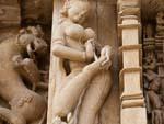 A woman removing a thorn from her foot carving at Parsvanath Temple