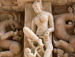 A women bending her leg carving at Parsvanath Temple