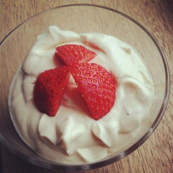 Strawberries in a glass dish with mint and Pimm's whipped cream