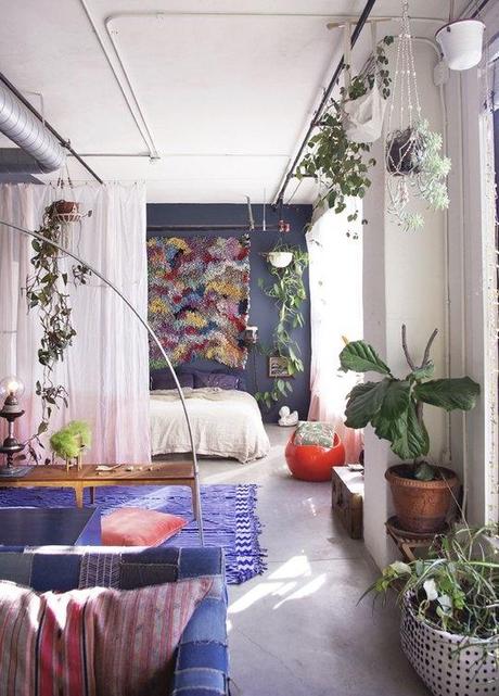 SO much great texture packed in one apartment. love the plants, the colors, and the incredible textile piece hanging above the bed.