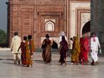 Colourfully dressed locals walking around the Taj Mahal