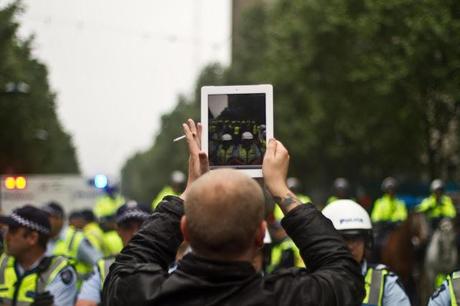 man holding iPad at occupy melbourne