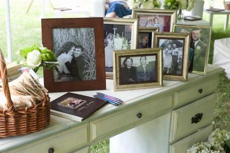 desk with photos used to sign guest book at home wedding