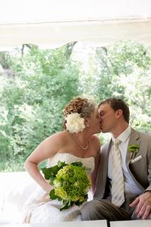 bride and groom kissing with green flowers