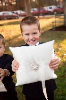 young ring bearer holds pillow