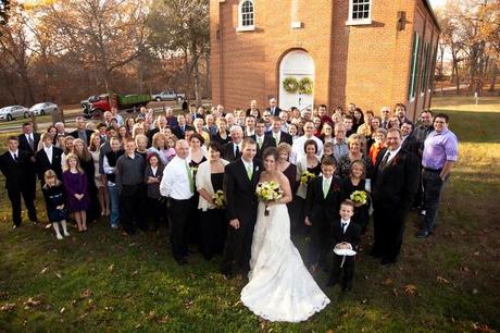 wedding party and wedding guests pose outside church