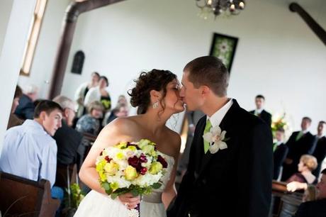 groom and bride kiss in church