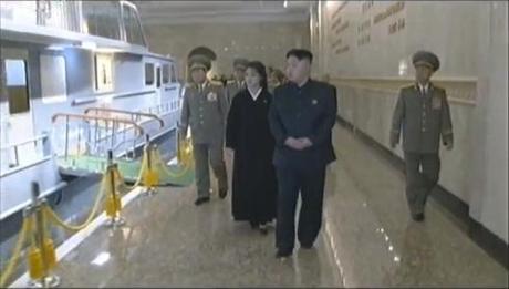 Kim Jong Un (R) and Ri Sol Ju (2nd R) view the display of KJI's boat (Photo: KCTV/KCNA screengrab)