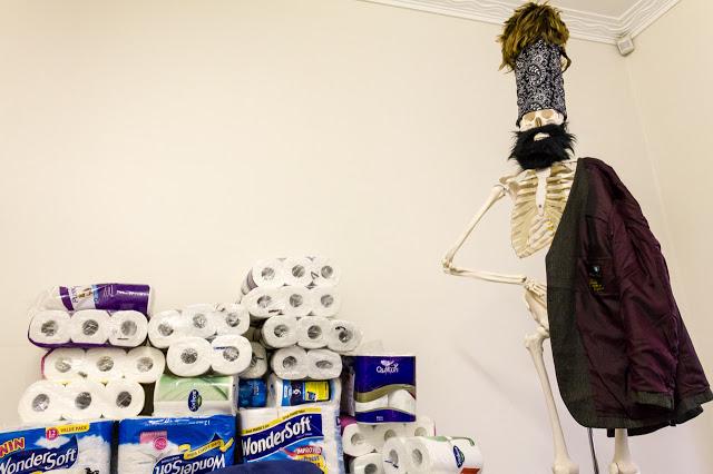 toilet rolls with a skeleton standing next to them