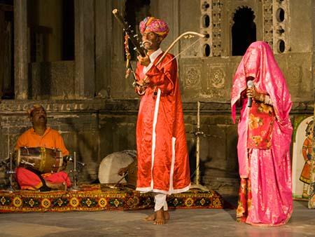 Elderly man playing a ravanahatha and a veiled women singing