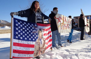 Belinda Ayze, Navajo, of Flagstaff, Arizona, holds a protest sign during a rally on December 21 to oppose snowmaking with treated wastewater on the San Francisco Peaks.