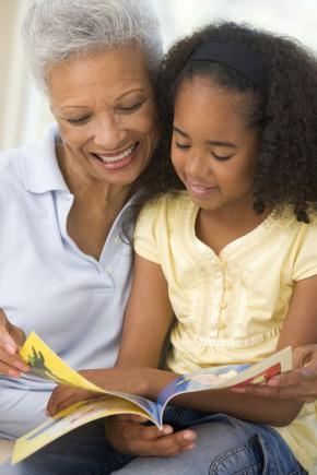 Grandmother and granddaughter reading and smiling