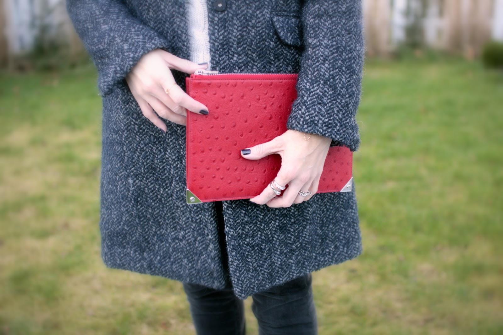 The dark grey jeans and the bright red clutch