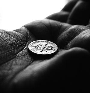 English: Artistic photograph of a dime in a ha...