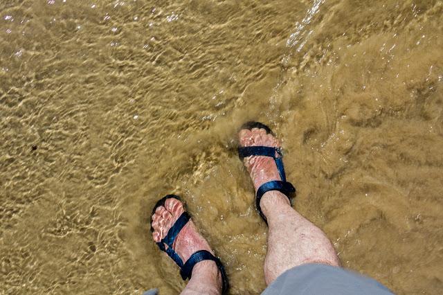 standing in shallow water with sandals on