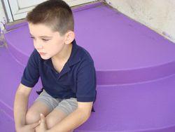 Samuel sits on purple chairs on the stairs outside my back door.
