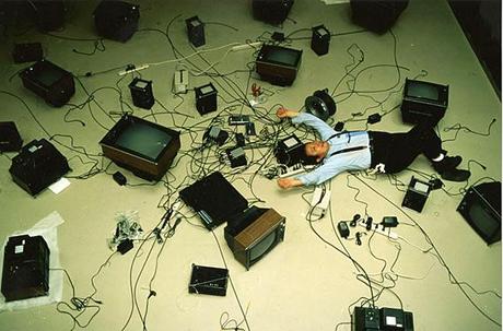 Paik on floor with TVs