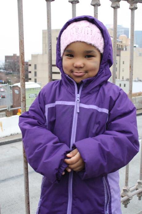 Yesterday, I spent the day riding around the city, interviewing people for a really cute relationship story. One of my subjects was a 7-year-old girl, the sister of the cherub above. This little cutie started crying because I didn’t take a photograph of her along with her sister.
My heart broke; I had her pose for me to make up for it. I’m happy she did, because those gorgeous cheeks are going to bring a smile to my face for weeks.  