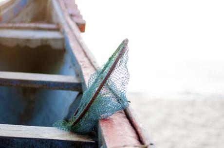 A fisherman's boat resting on the beach.