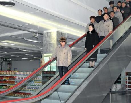 Kim Jong Il (front) at his last reported public appearance at the Kwangbok Market in December 2011.  This was the last image of the late leader when he was alive telecasted in DPRK state media before he died on 17 December 2011 (Photo:  Rodong Sinmun)