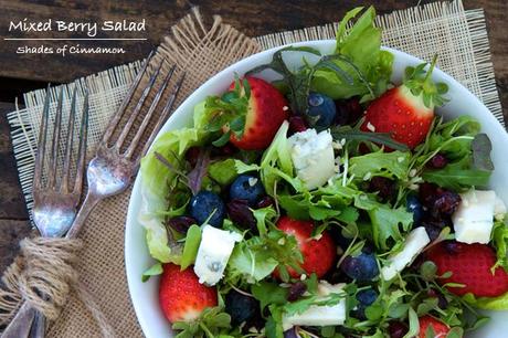 Mixed berries in a salad of baby greens with cheese and nuts