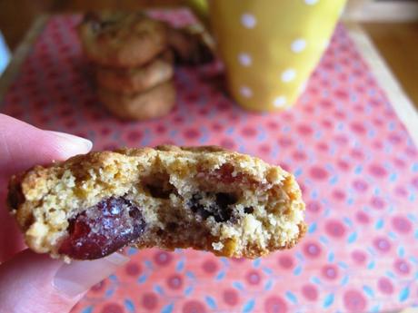 Cherry, chocolate, cornflake and coconut cookies with a bite taken out of it.