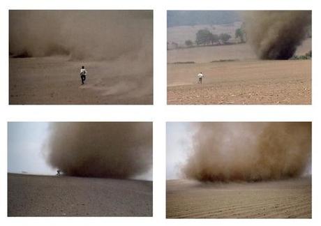 “Every year since 2001 Alÿs, at the highpoint of the dry season in March, drives his car to the southeast edge of Mexico City where smoky clouds rise from cornfields burning after the harvest, and grey swirls of ash and sand loom on the horizon. He carries his video camera and runs toward the tornadoes hoping to catch them as a surfer catches a wave. His nose and mouth are protected only by a handkerchief. Once he reaches one, he runs into the eye of the storm and stays as long as possible. This is an absurd act but he tries to forge a moment of bliss in the midst of chaos.” —Un-marked source
(The perfect allegory for life.)