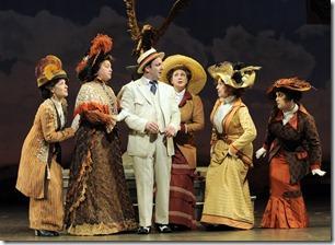 The ladies of River City (from left) Anna Hammonds, Liz Pazik, Elizabeth Dowling, Caron Buinis and Lauren Villegas pick a little, talk a little, pick a little and talk a little with traveling salesman Harold Hill (Stef Tovar) in Paramount Theatre’s production of The Music Man, directed by Rachel Rockwell.  (photo credit: Liz Lauren)