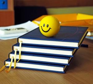 new blue organizers and yellow smiley ball on office desk