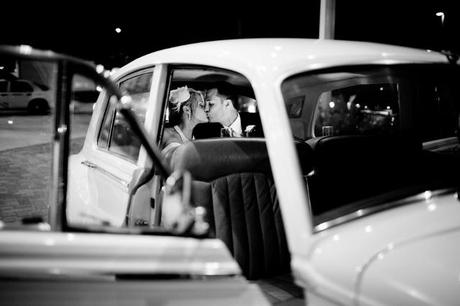 antique car with bride and groom kissing