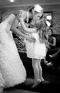 small girl and bride kiss