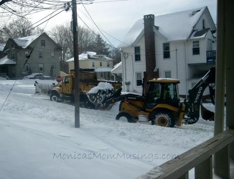 The backhoe arrives to start digging the plow out. He dumped that snow in our yard!