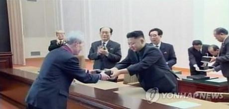 Kim Jong Un presents a gold watch bearing his late father's name.  Seen in attendance behind KJU are Kim Ki Nam (L), Kim Yong Nam (2nd L) and Kim Phyong Hae (4th) and behind KJU are officials of the KWP Central Committee Gifts Office (Gifts Hall) (Photo: KCNA-Yonhap)