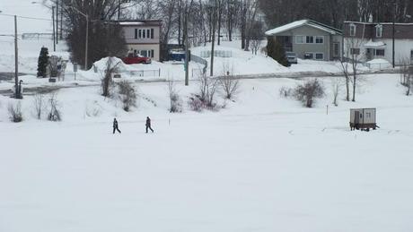 Two people cross-country ski on frozen river in Ottawa - Canada