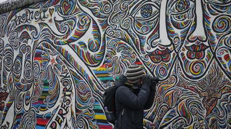 Blending in. Taking pictures at East-side Gallery - a colourful part of the Berlin Wall