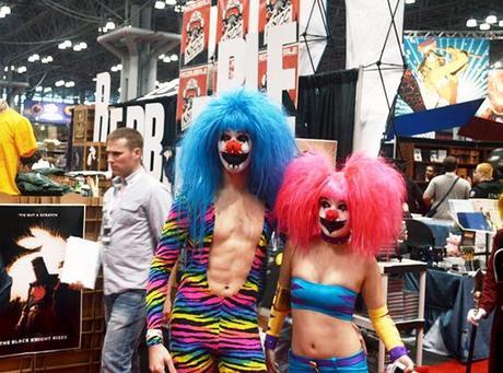 couple wearing clown style superhero costumes and posing in front of RedBubble booth at 2012 New York Comic Con comics and pop culture convention