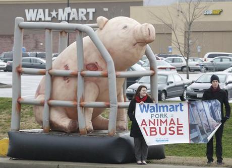 Lindsey Frost Cleary, left, and Nick Wallerstedt hold signs protesting the treatment of pigs by Walmart suppliers Tuesday outside of Walmart Supercenter along Signal Mountain Road in Chattanooga. Phil Letten, the national campaign coordinator for the animal rights organization Mercy for Animals, said that the group was calling for Walmart to follow competitors' leads and phase out farrowing crates used by their pork suppliers which confine pregnant or nursing pigs.