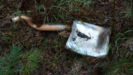 damaged car muffler and exhaust on side of road