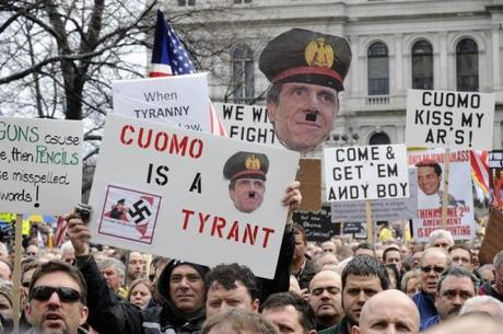 Gun owners and Second Amendment rights advocates rally during a pro-gun rally at the State Capitol in Albany, New York, February 28, 2013. New York Governor Andrew Cuomo is depicted as Adolf Hitler on placard in the foreground. Cuomo on January 15 signed into law one of the nation's toughest gun-control measures and the first to be enacted since the mass shooting in December 2012 at an elementary school in neighboring Connecticut. REUTERS/Hans Pennink (UNITED STATES - Tags: POLITICS CIVIL UNREST TPX IMAGES OF THE DAY)