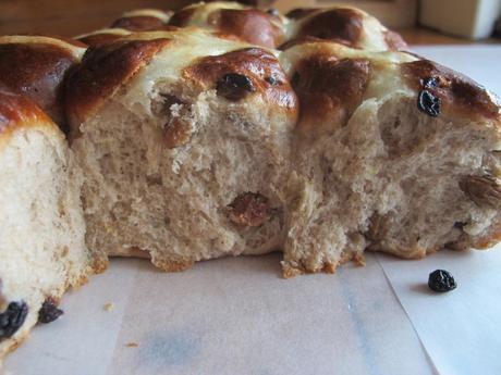 Close up of hot cross bun with sultanas