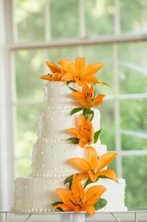orange flowers on white wedding cake