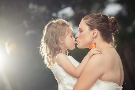 bride and young daughter kiss