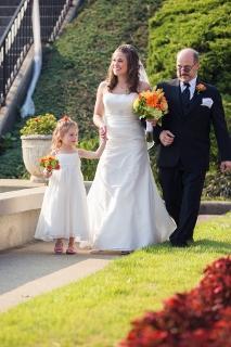 bride and daughter walk down aisle with father of the bride