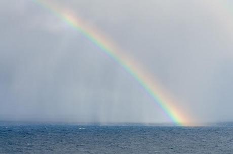 rainbow and rain over ocean