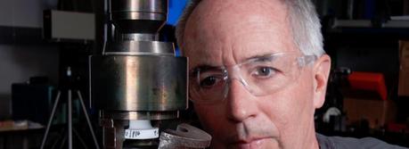 Sandia National Laboratories researcher Tom Crenshaw sets up a specimen in a test frame that will pull a solder joint apart to determine its tensile strength. He co-authored a paper that won the Best of Proceedings category in the Surface Mount Technology Association’s International 2012 Best Papers conference. (Photo by Norman Johnson)