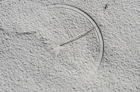 circle in sand caused by piece of grass