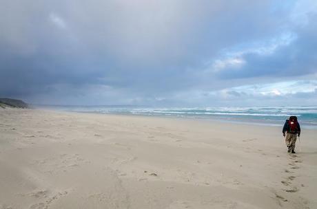 walking on beach with rain cloud overhead