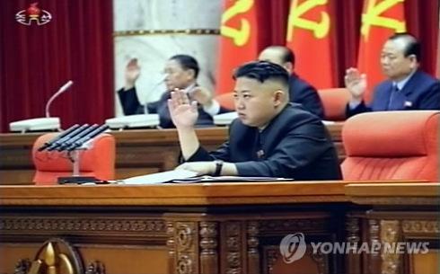 Kim Jong Un raises his right hand at the start of the KWP Central Committee plenary meeting in Pyongyang on 31 March 2013.  Also seen in attendance on the platform (rostrum) behind KJU are DPRK Cabinet Vice Premier Kang Sok Ju (L) and KWP Secretary Pak To Chun (R).  (Photo: KCTV-Yonhap)
