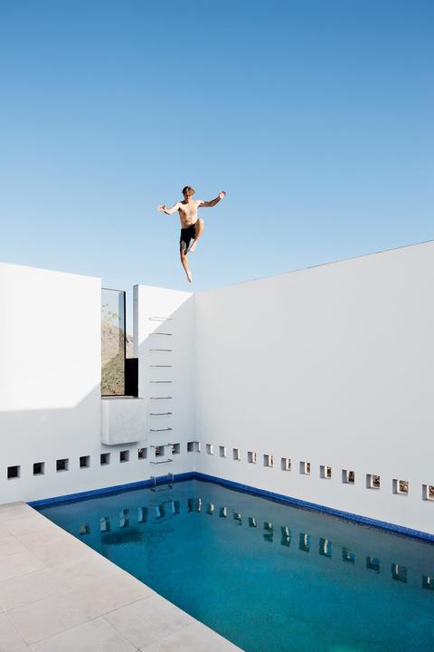 Thomas Hyland jumping into the pool of the Dialogue house.